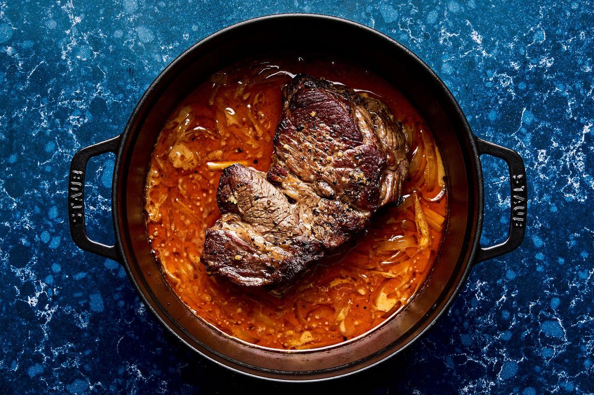 red curry beef made with coconut milk, red curry paste, lime juice, onion, garlic, lemongrass, and ginger in a pot