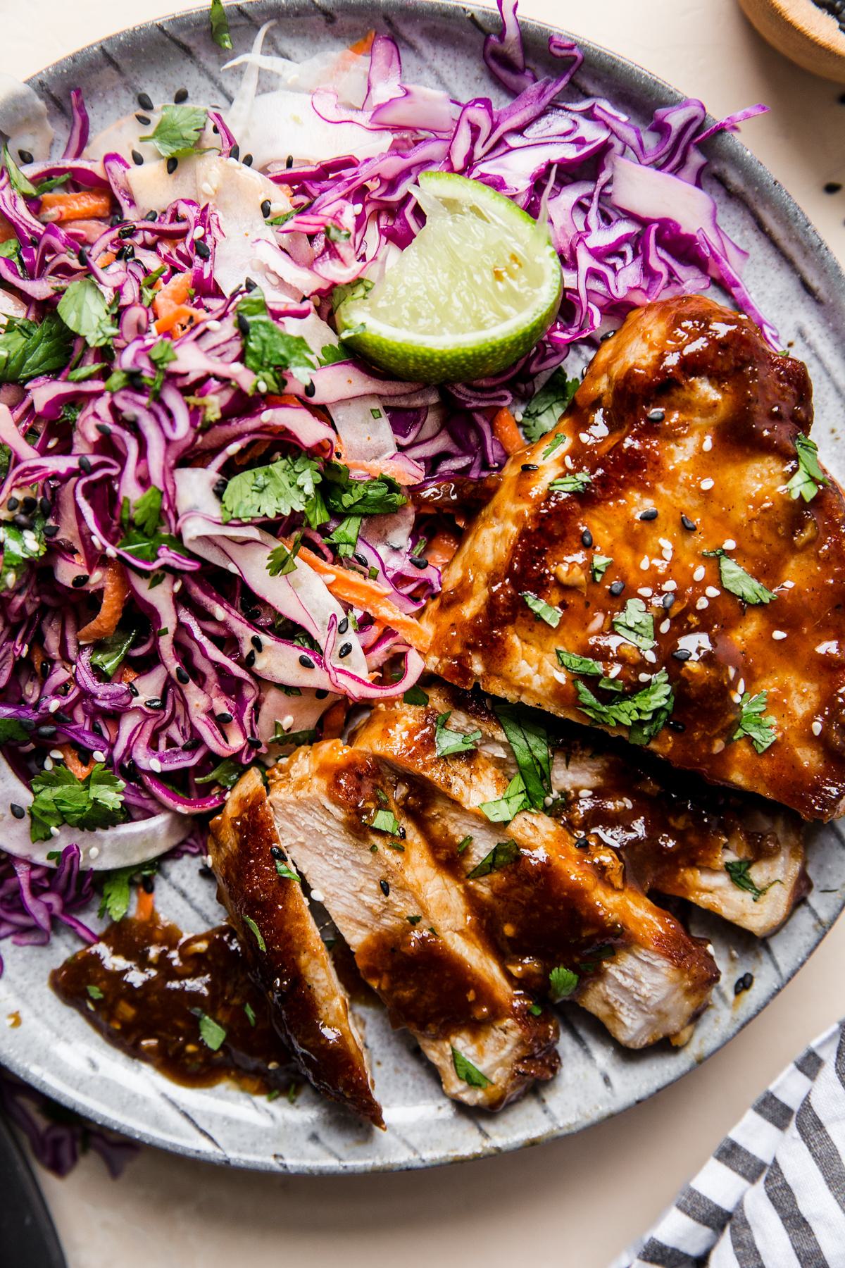 Hoisin Glazed Pork Chops on a plate with Asian coleslaw