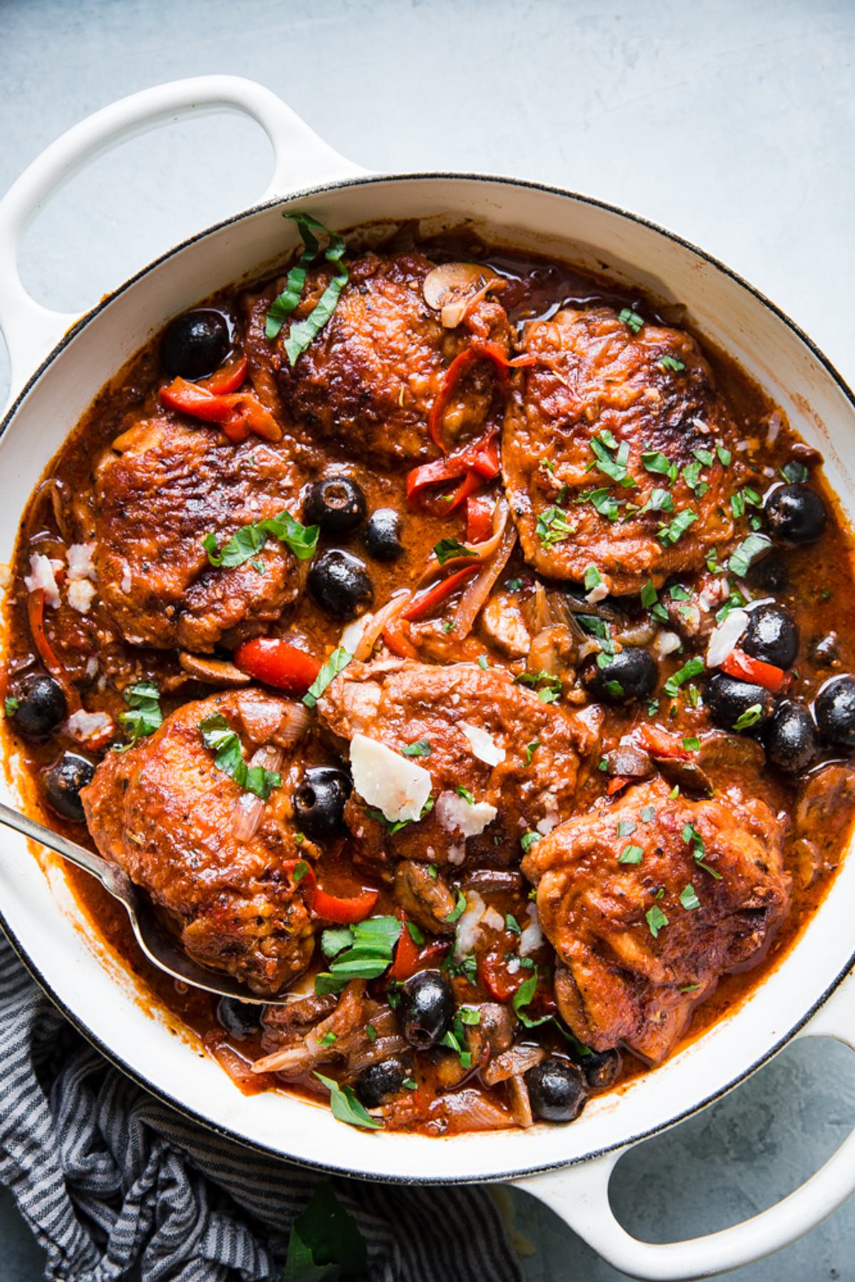 homemade chicken cacciatore recipe in a while pot with olives and tomatoes.