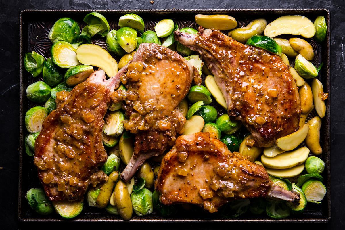 4 seared pork chops on a sheet pan with apricot jam, mustard and butter with Brussels sprouts and fingerling potatoes