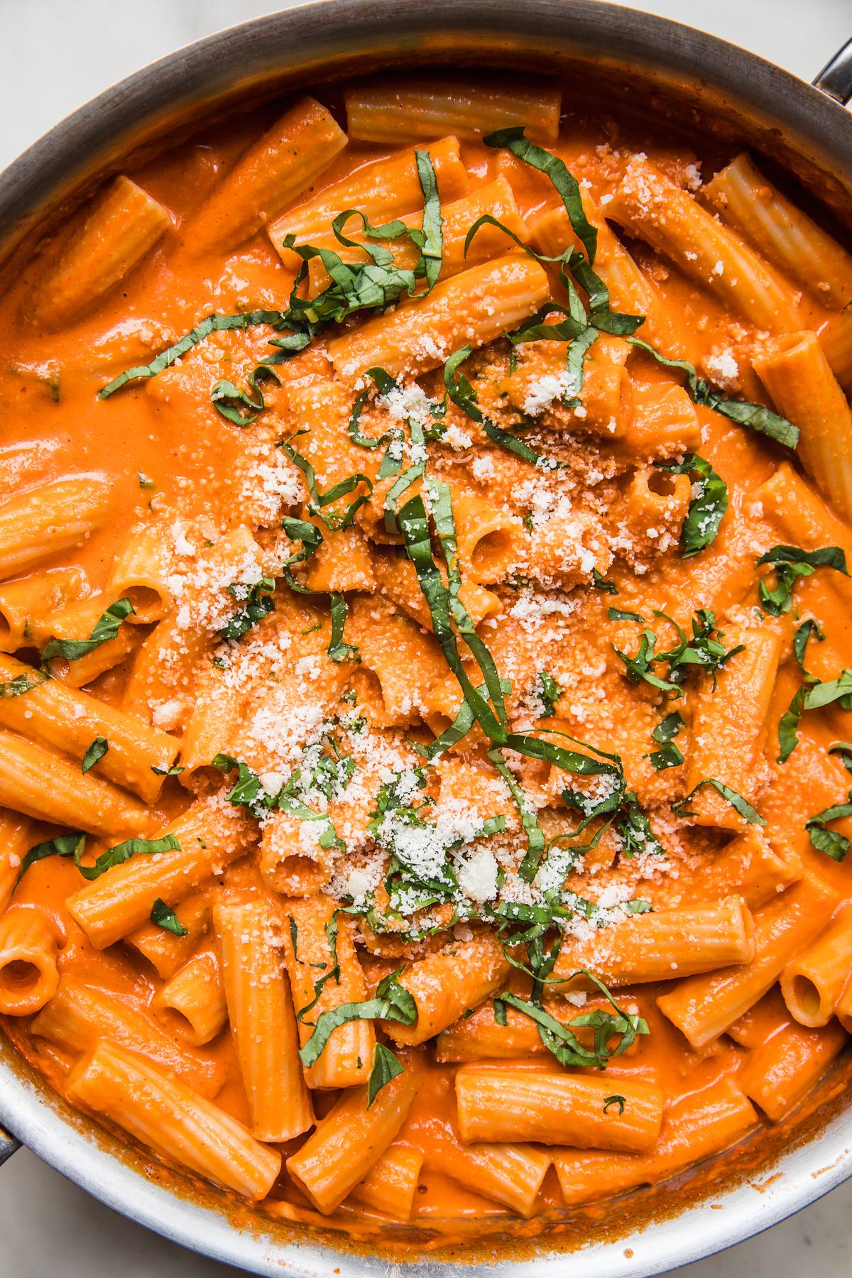 a pot of homemade pink sauce Tortiglioni pasta topped with parmesan and fresh basil