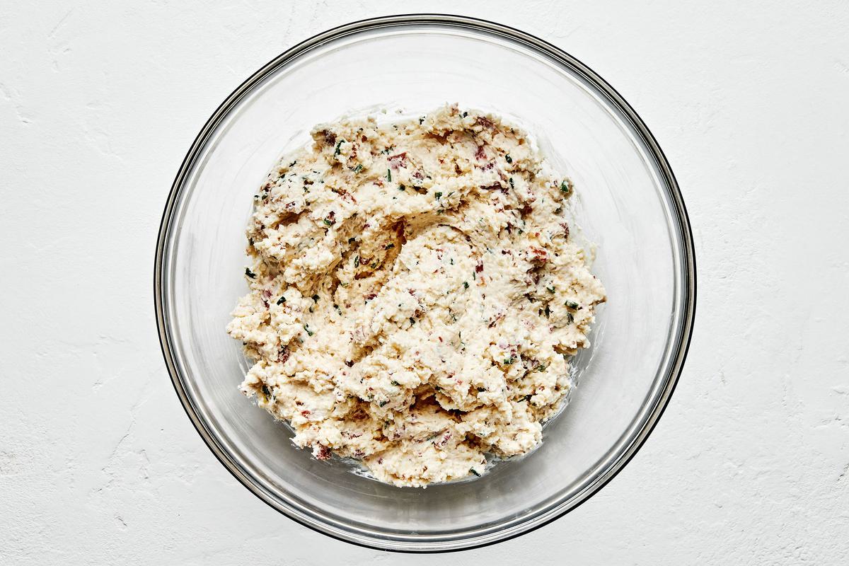 parmesan, cream cheese, bacon, chives, butter, panko, salt, pepper & garlic being mixed in a bowl