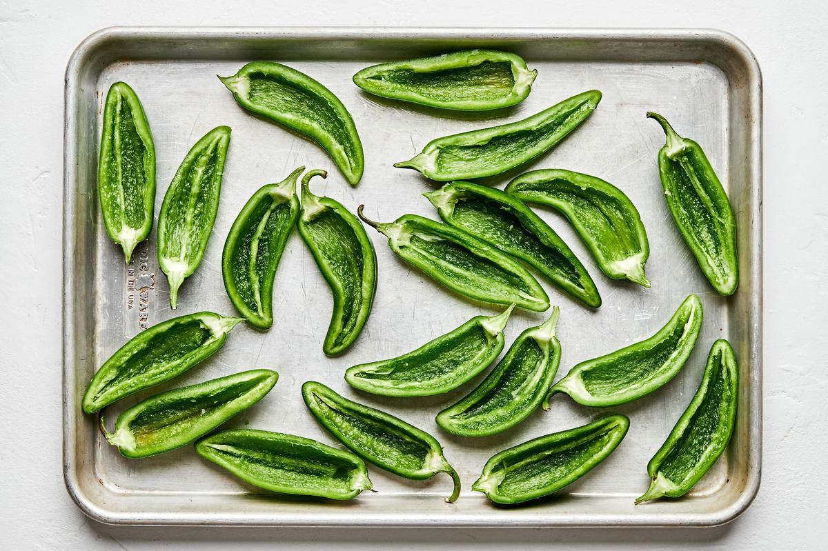 jalapeño sliced in half and deseeded on a baking sheet