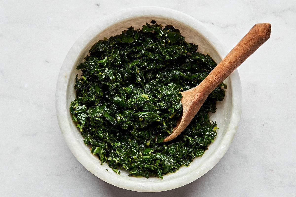 Homemade fresh mint sauce in a bowl with a small wooden spoon.
