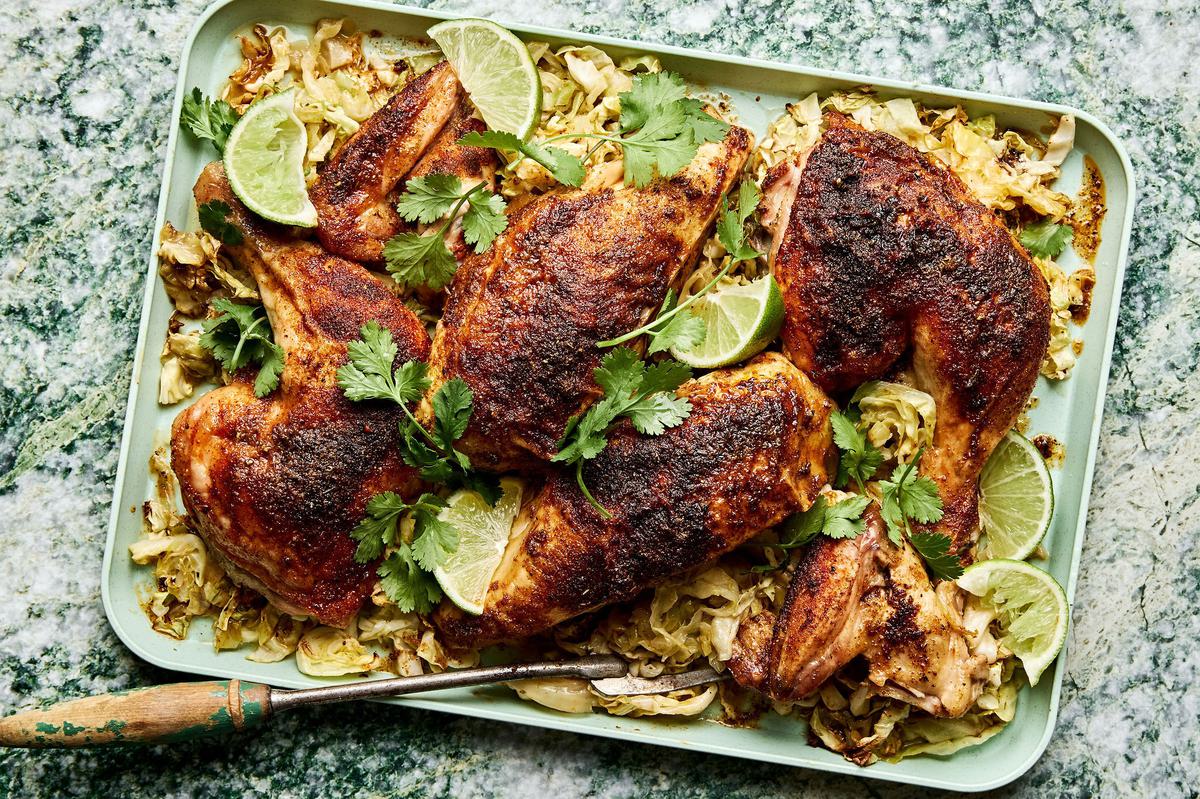 a roasted chicken cut in quarters served on top of roasted cabbage on a platter